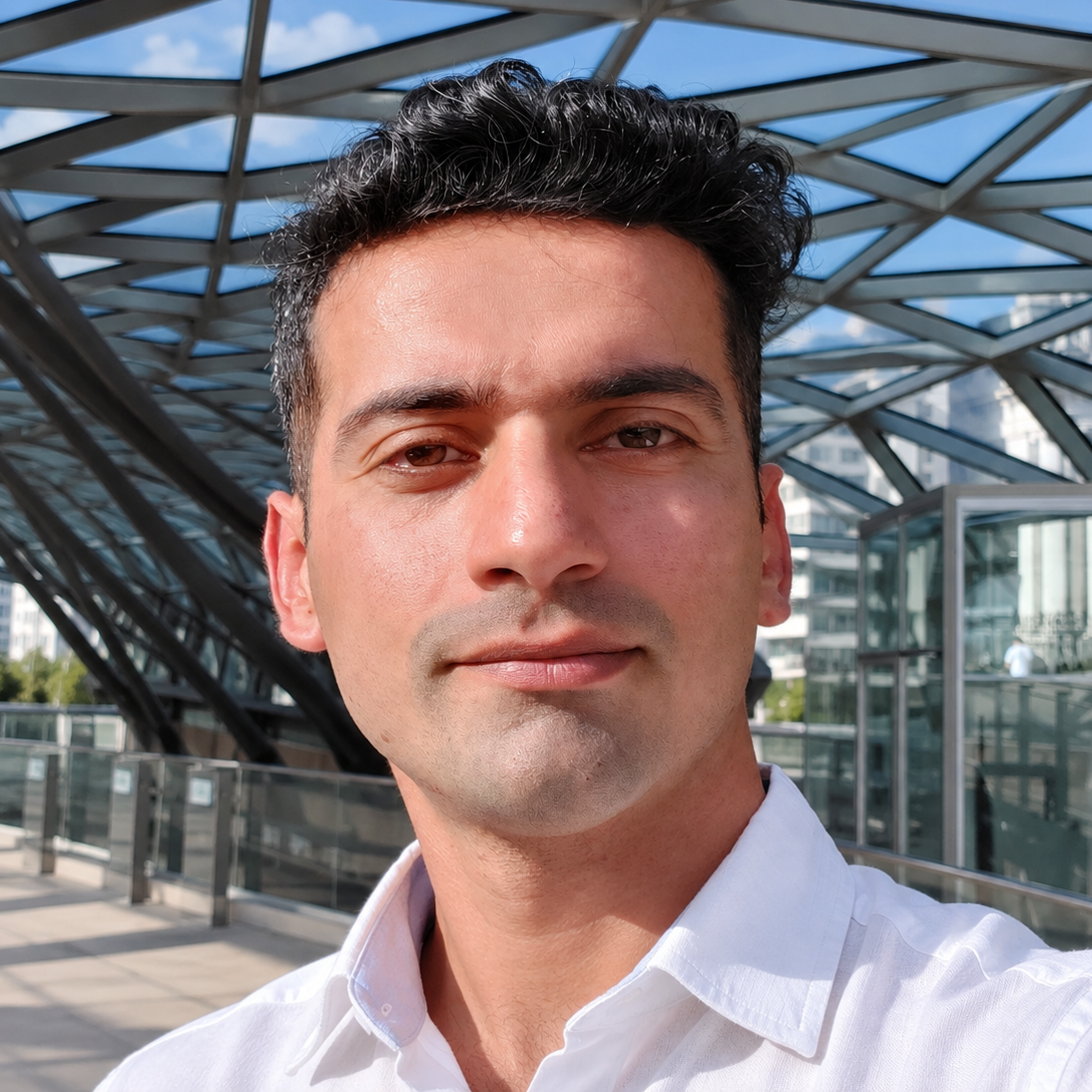 Portrait of Mehdi Razi, Festival Director, standing beneath a glass and steel canopy.